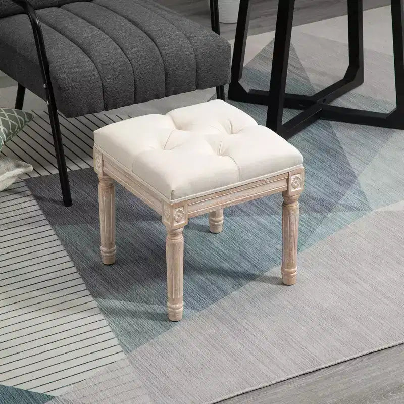 Ottoman carré beige avec assise capitonnée et pieds sculptés, simple