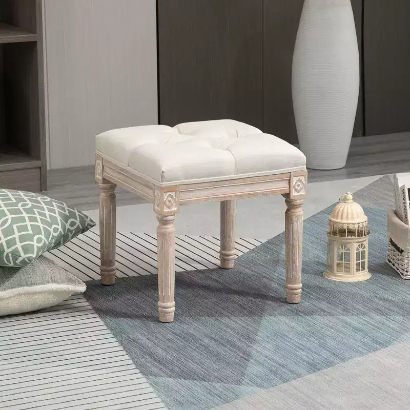 Ottoman carré beige avec assise capitonnée et pieds sculptés, simple